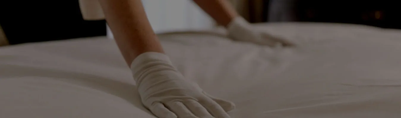 Hotel staff preparing a clean bed in a luxury room at Hotel Aketa Dehradun 